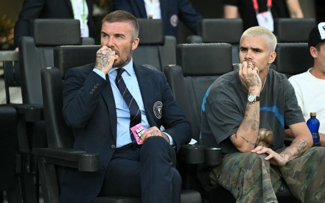 Inter Miami co-owner David Beckham snacks on his BEEUP Fruit Snacks alongside his son, Romeo James Beckham, during the MLS regular season match between Inter Miami CF and Nashville SC at Chase Stadium in Fort Lauderdale, Florida, on July 12, 2025. (Photo by Chandan Khanna / AFP) (Photo by CHANDAN KHANNA/AFP via Getty Images)