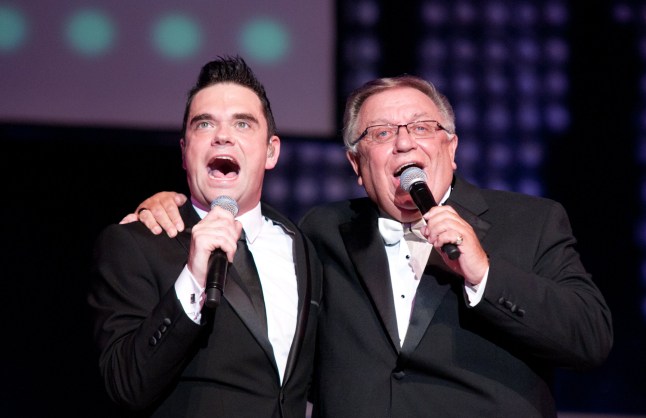 LEICESTER, UNITED KINGDOM - MAY 18: JK as Robbie Williams and Robbie Williams' father, Pete Conway, out of retirement for one night, perform in a one time special showing of 'Let Me Entertain You' performed for DVD at De Montfort Hall And Gardens on May 18, 2012 in Leicester, United Kingdom. (Photo by Ollie Millington/Redferns via Getty Images)