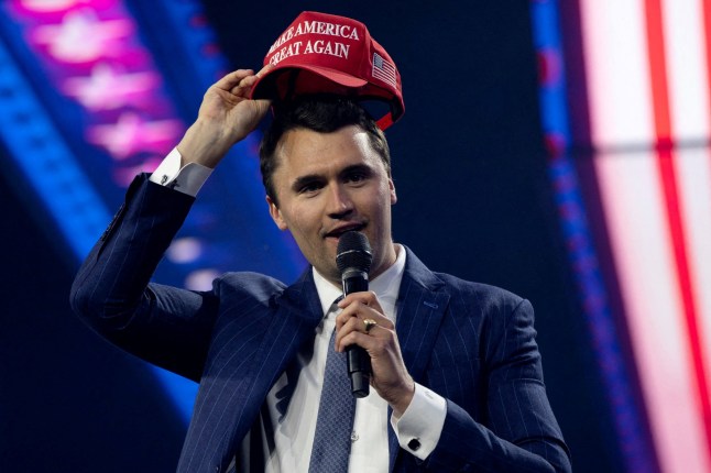 FILE PHOTO: Charlie Kirk, Turning Point USA founder, puts on a MAGA hat during the AmericaFest 2024 conference sponsored by conservative group Turning Point in Phoenix, Arizona, U.S. December 19, 2024. REUTERS/Cheney Orr/File Photo