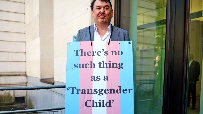 LONDON, ENGLAND - SEPTEMBER 4: Graham Linehan poses with a placard reading "There's no such thing as a transgender child" outside Westminster Magistrates Court on September 4, 2025 in London, England. Irish comedy writer Graham Linehan is appearing in court charged with harassment without violence and criminal damage in connection with an incident that took place last year. Linehan, who is known for co-creating TV sitcoms such as Father Ted and The IT Crowd, has also been outspoken against the trans-rights movement. Linehan was arrested on Monday on suspicion of inciting violence over anti-trans social media posts he made earlier this year. His latest arrest has sparked a backlash from free speech advocates. (Photo by Dan Kitwood/Getty Images)